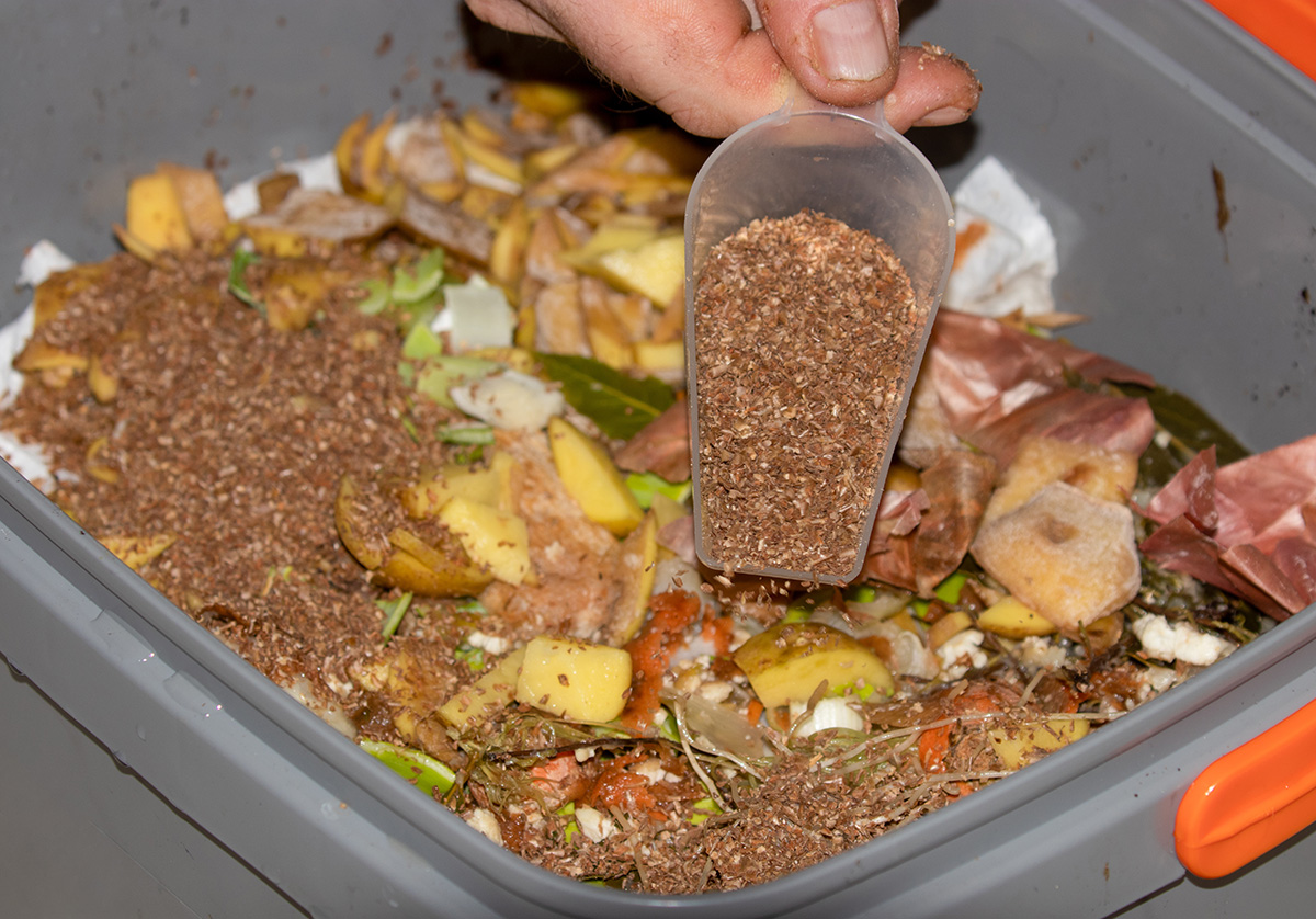 Adding bran to a bokashi bin