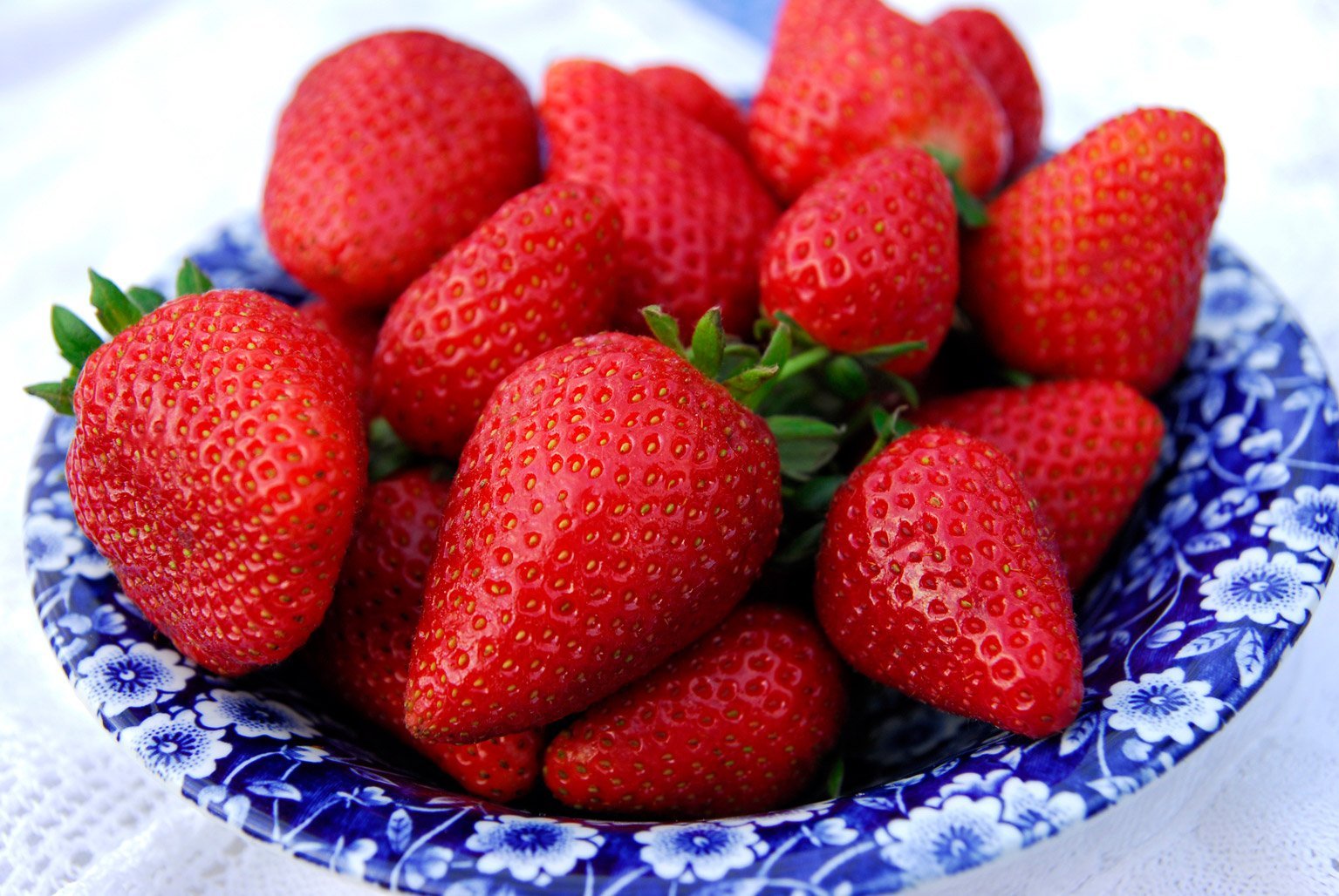 blue and white plate of strawberries