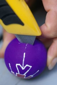 making a small cut in polystyrene ball