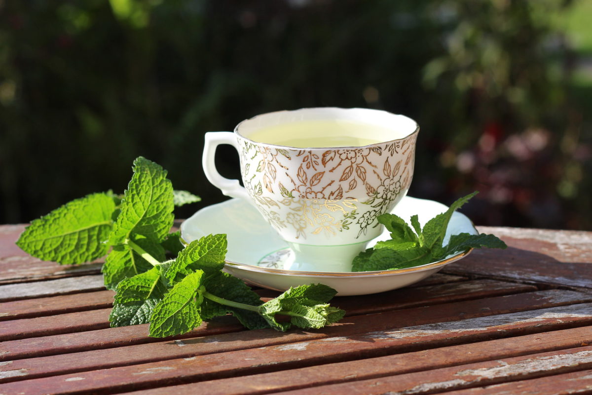 ornate teacup and saucer with mint leaves