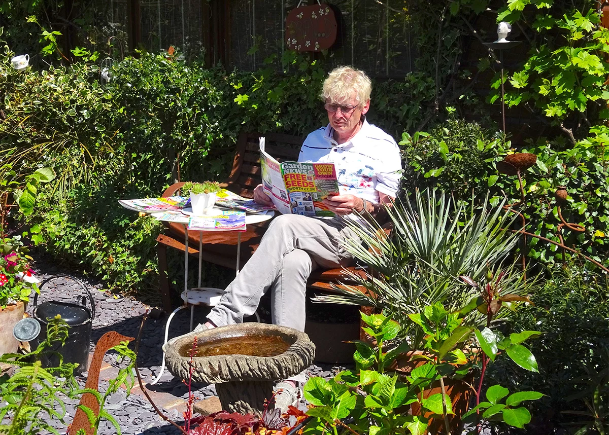 Geoff Stonebanks reading in the garden at Driftwood