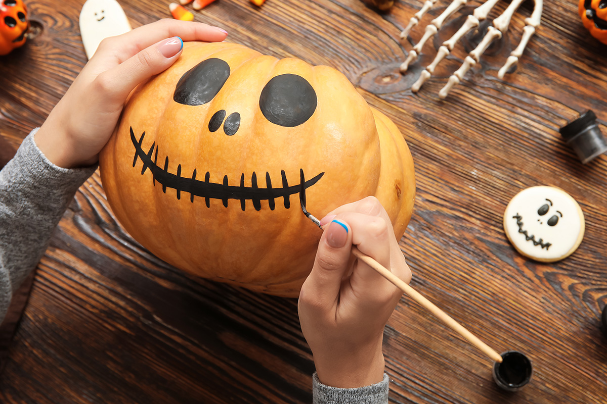 Painting a face on a Halloween pumpkin