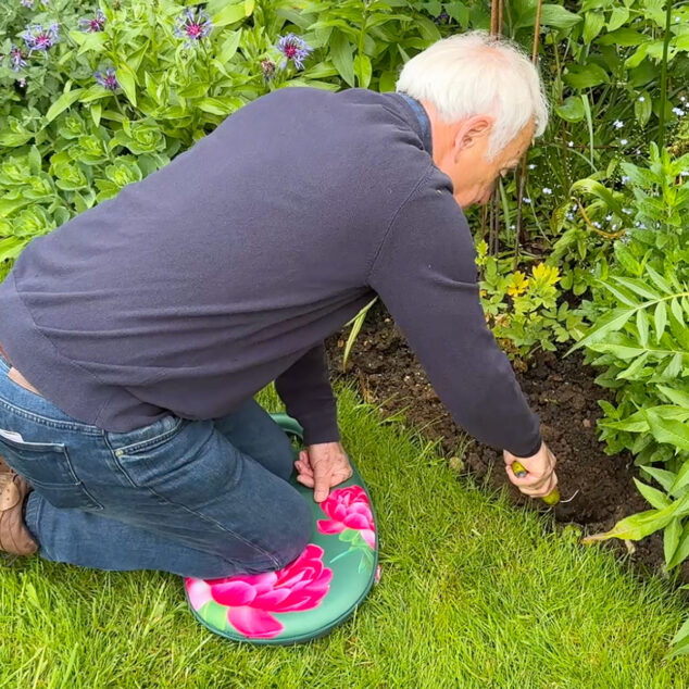 Richard using garden kneeler on lawn