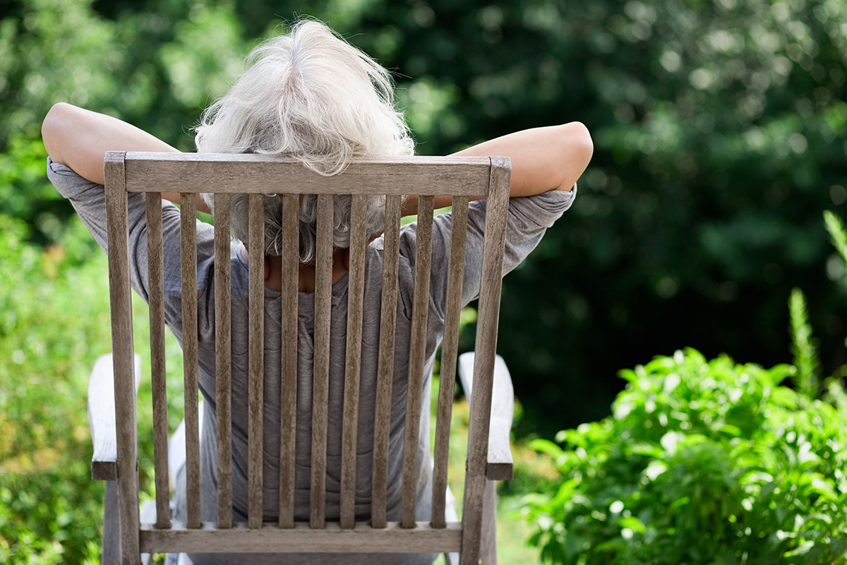 Rear view of woman relaxing in garden chair