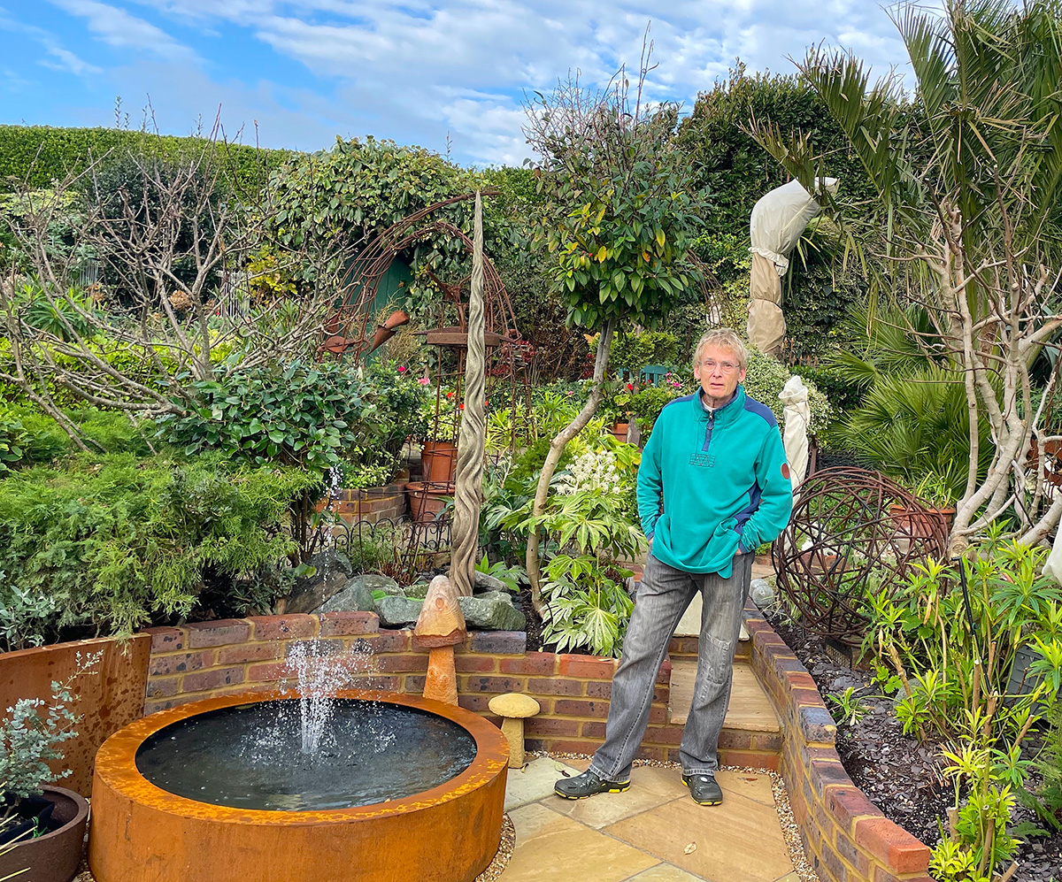 Geoff Stonebanks stood next to his corten steel water feature 
