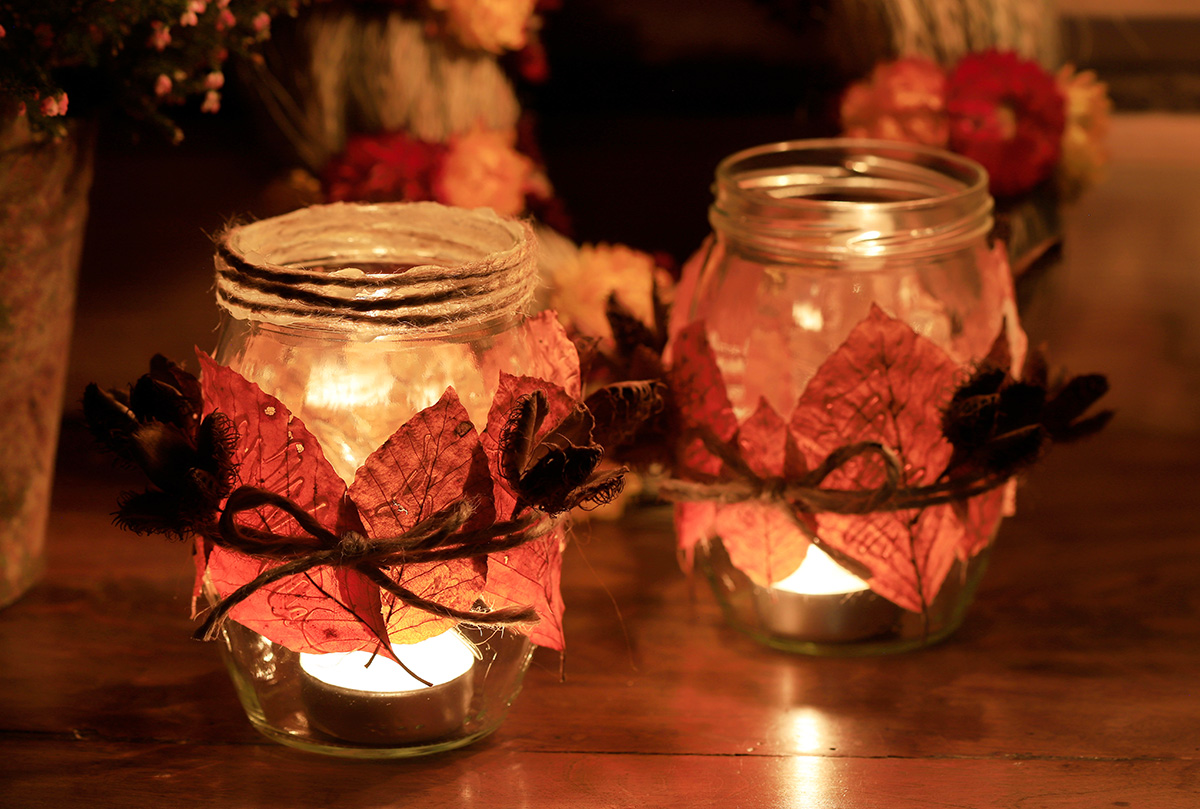 Lanterns made from jam jars decorated with autumn leaves